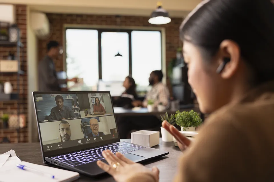 A woman taking part in a video meeting from a café