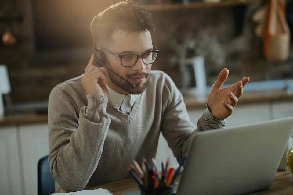 A person speaking on a laptop call from home
