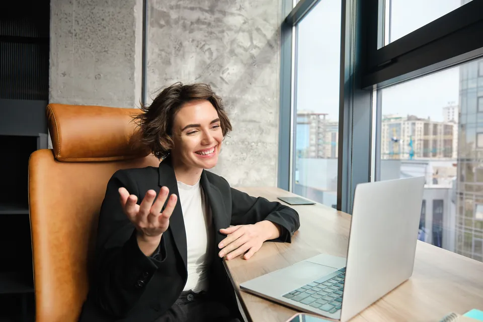 A woman talking during a meeting on her laptop